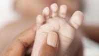 Close up of mother hands massaging baby foot.